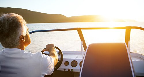 Marine Audio: Older gentleman driving a speed boat with a windsheild and upgraded device dash
